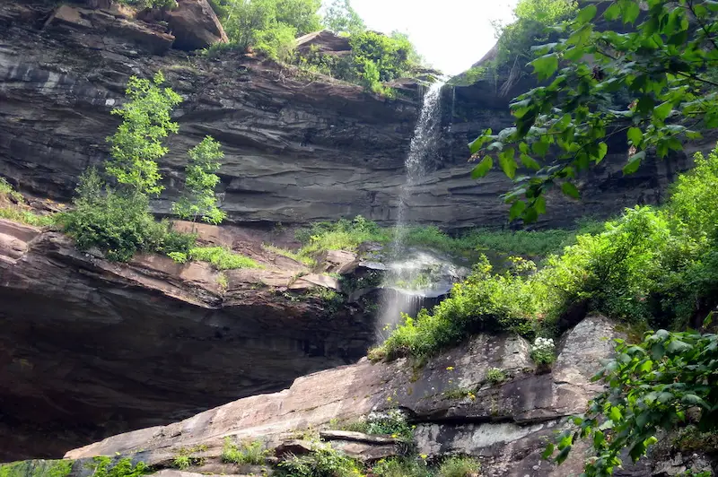 Secluded waterfall and lush green cliffs in the Catskills mountains, New York digital detox retreat destination in the USA