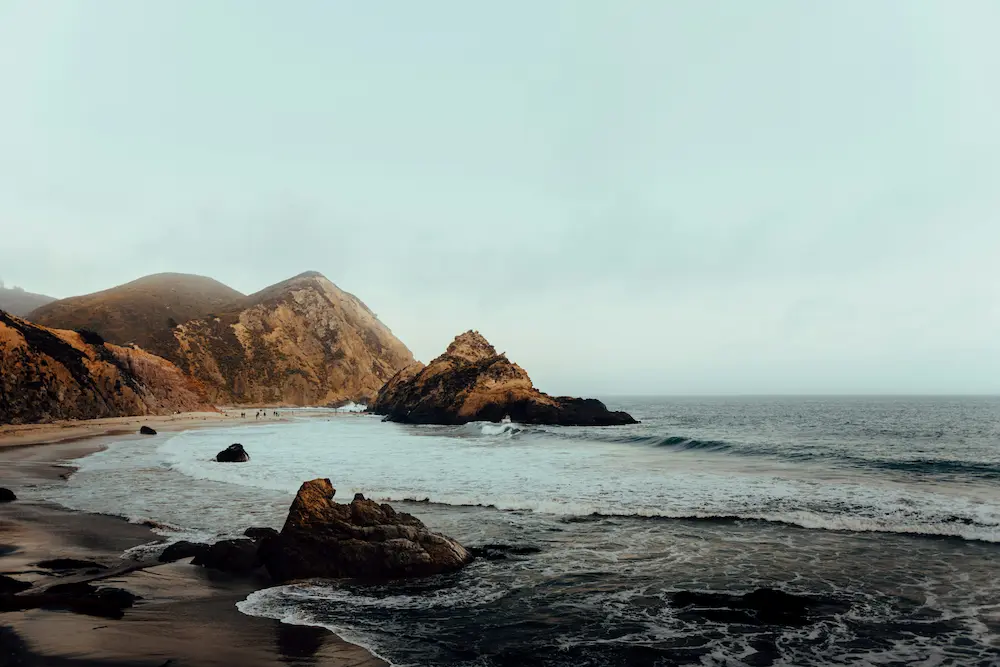 Misty Pfeiffer Beach with rugged cliffs and Pacific Ocean waves in Big Sur, California digital detox retreat destination USA
