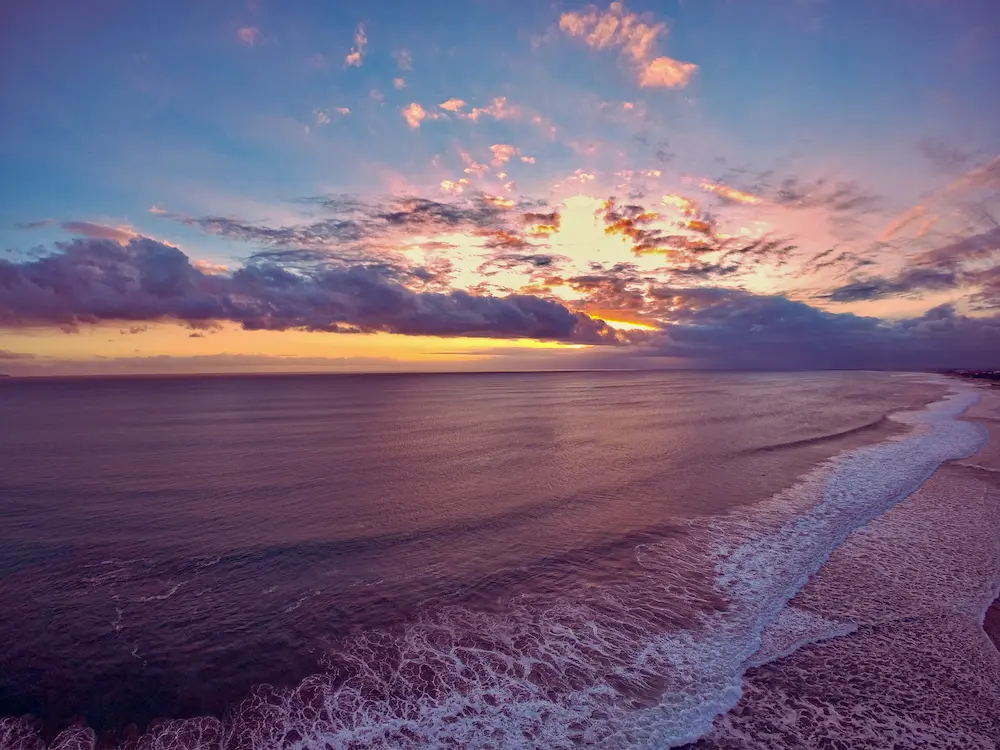 Golden sunset over the ocean and waves at Seminyak beach, Bali digital detox retreat destination in Indonesia